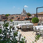 Luxurious rooftop lounge bar with plush seating, overlooking the iconic Pantheon dome and Roman cityscape at Orient Express La Minerva.