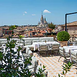 Luxurious rooftop lounge bar with plush seating, overlooking the iconic Pantheon dome and Roman cityscape at Orient Express La Minerva.